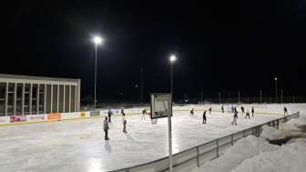 The illuminated natural ice rink in Sils i.D. in the evening