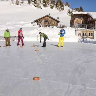 Curling on the natural ice rink at the Alp Raguta mountain hut