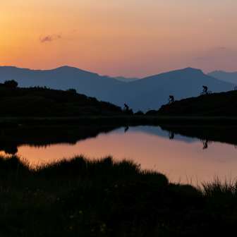 Bikers at sunrise at Lake Pascuminer on the Heinzenberg